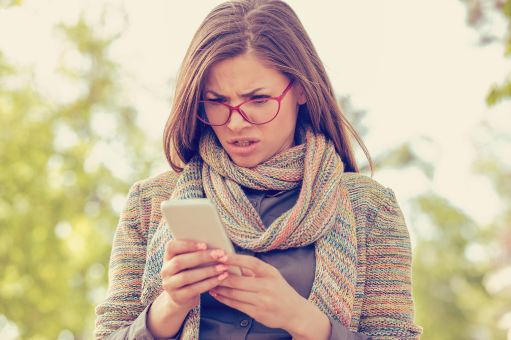 woman looking at ugly website on smartphone - aspire digital solutions website design